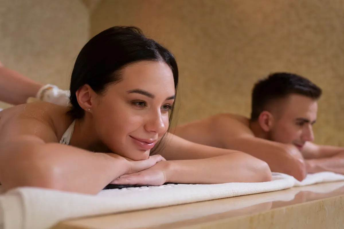 Couple relaxing side by side on massage tables during a couple massage
