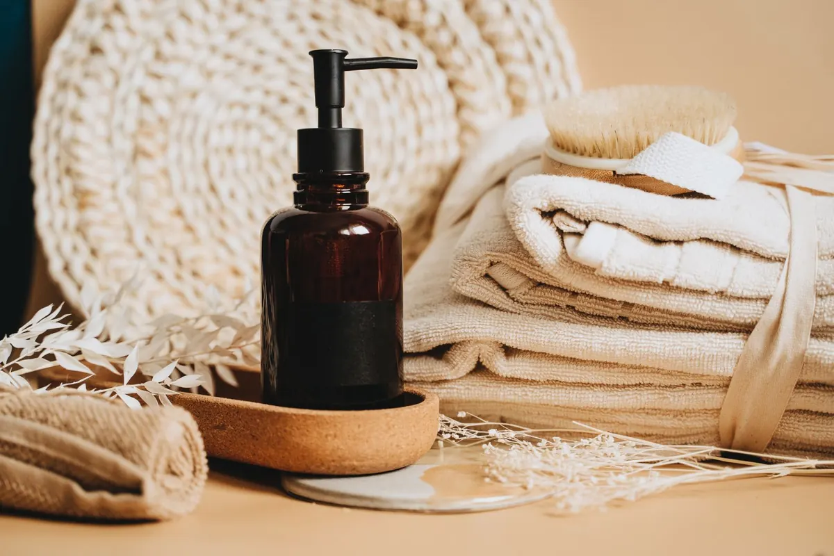 Massage oil, folded towels and natural wooden spa accessories